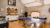 The Barns – Exclusive Hire, Herefordshire – Games room with table tennis, foosball table and exposed stone fireplace.