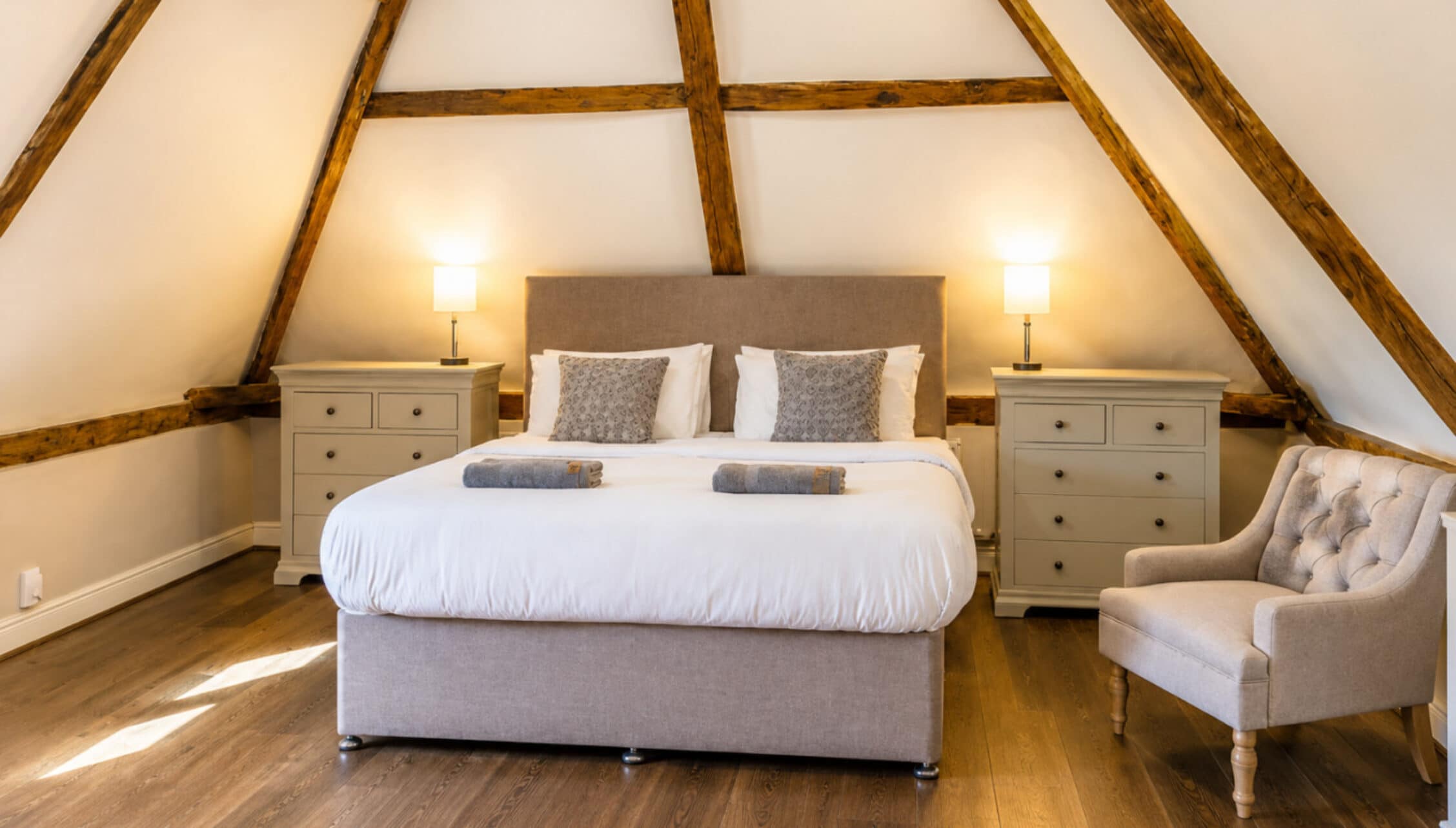 Catton Old Hall, Norfolk – Attic bedroom with exposed wooden beams, king bed, and twin bedside tables.