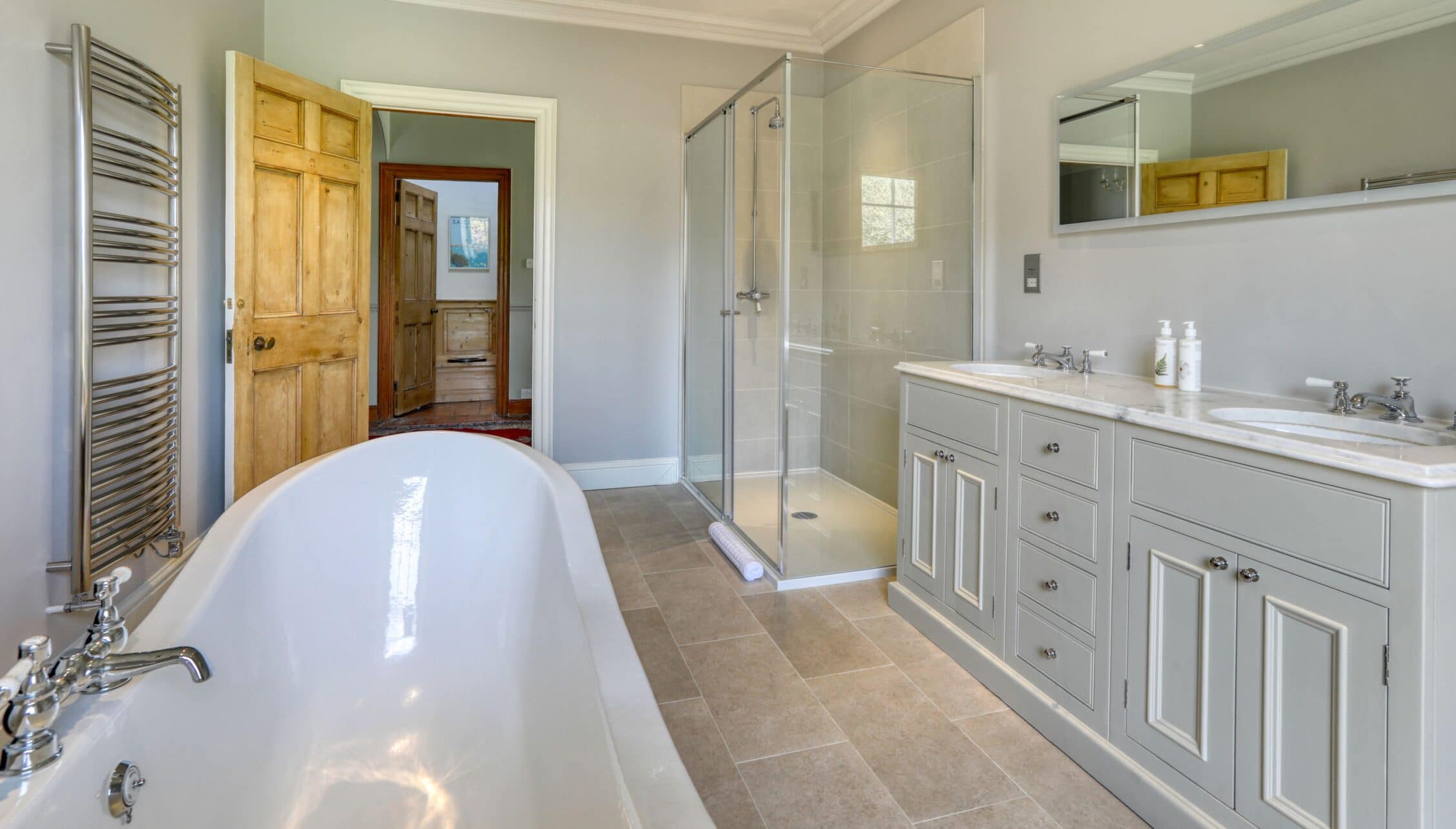 Gitcombe House, Devon – Spacious bathroom with freestanding bathtub, walk-in shower, and double vanity.
