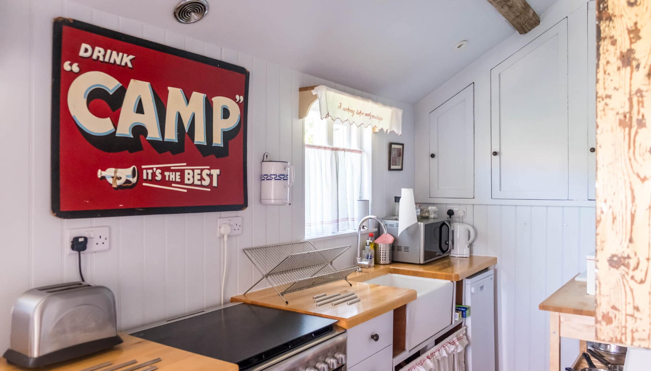 Barton Court, Herefordshire – Kitchen with vintage Camp advertising sign and wooden worktops.
