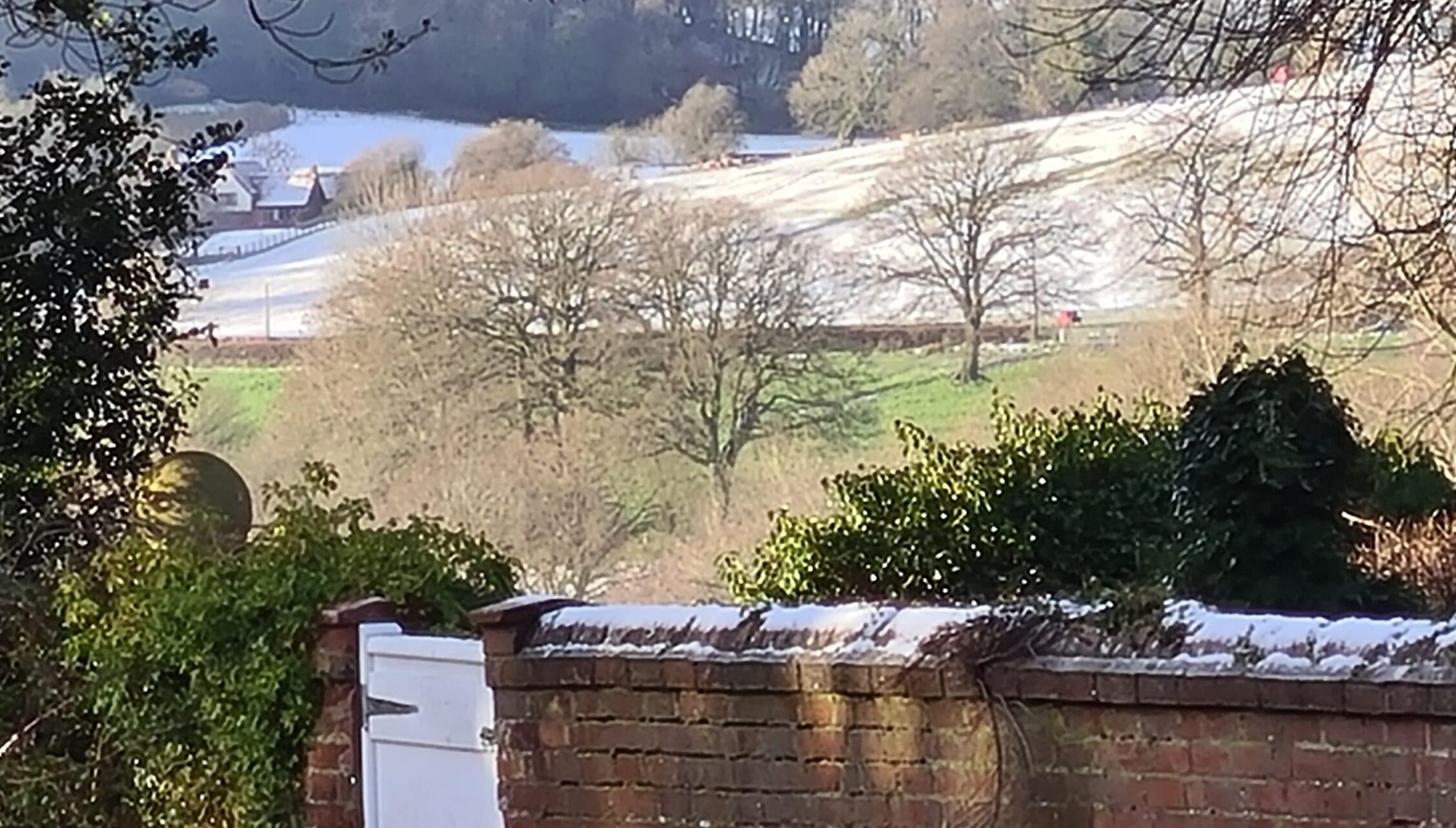 Barton Court, Herefordshire – Winter countryside view with bare trees, snow-covered fields and distant lake.