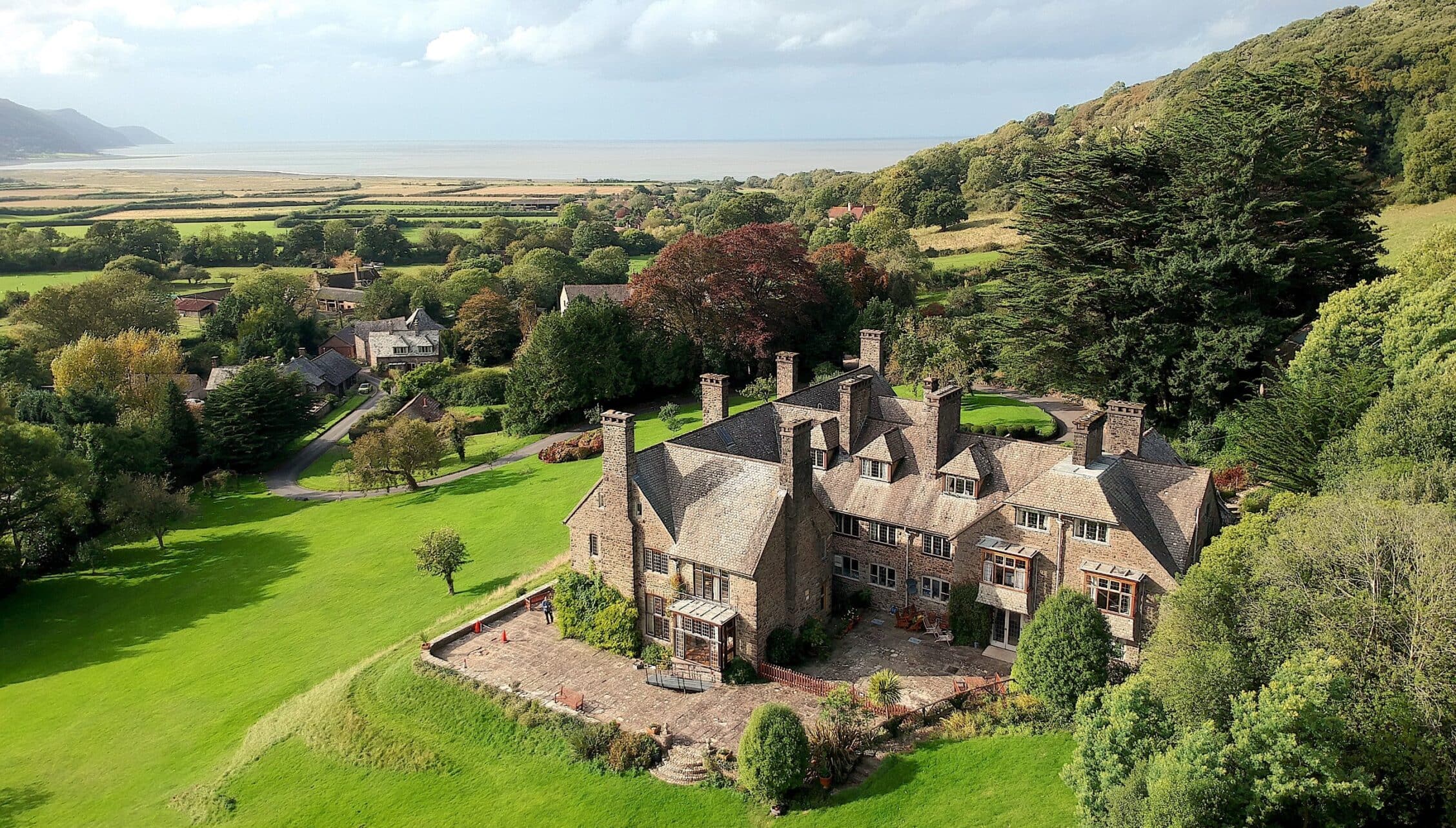 Bossington Hall, Somerset – Stone country mansion with multiple chimneys set in extensive parkland and woodland grounds.