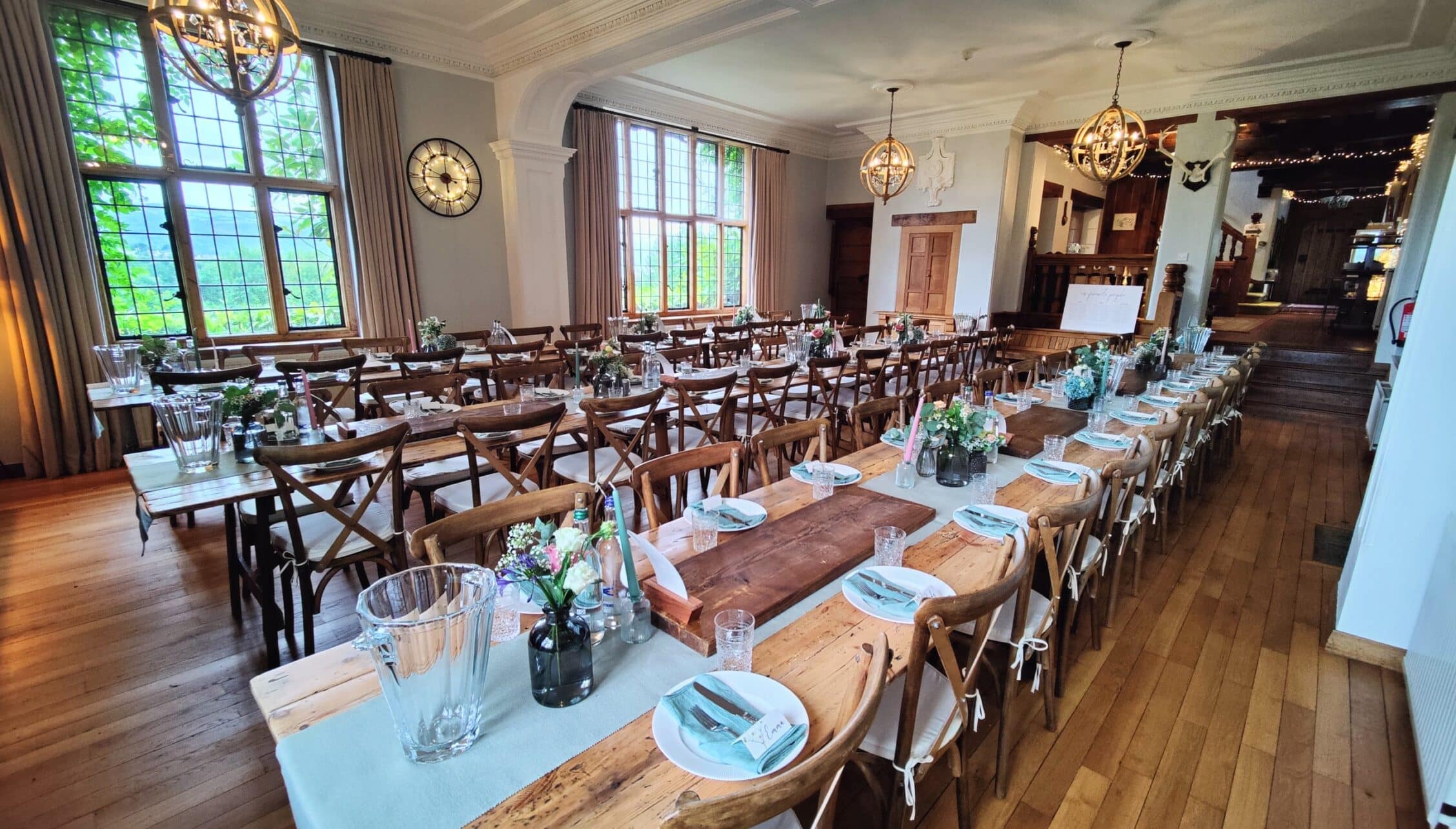 Bossington Hall, Somerset – Formal dining room with long wooden tables, cross-back chairs, and tall sash windows.