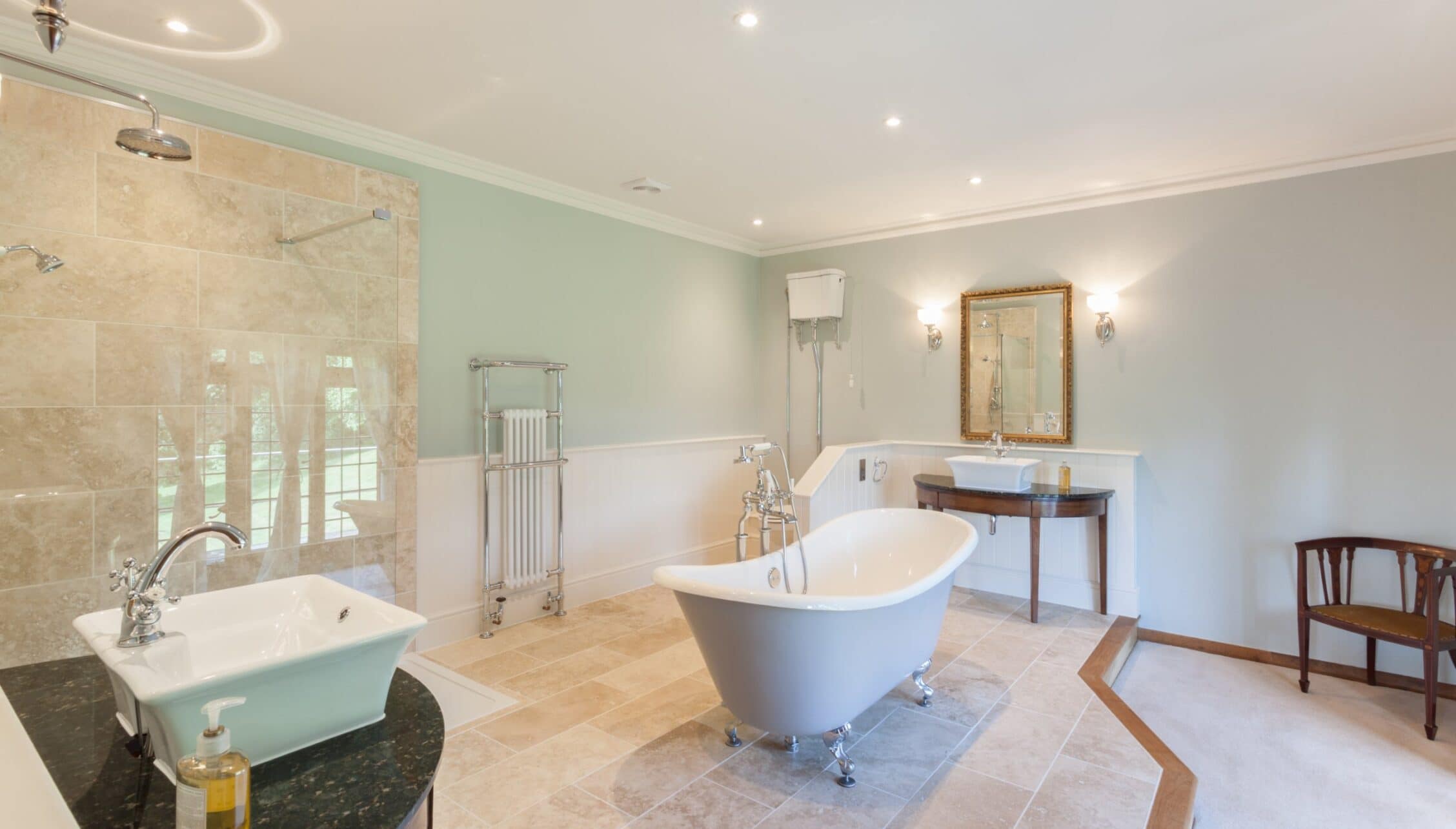 Bossington Hall, Somerset – Spacious bathroom with freestanding baths, walk-in shower enclosure and marble flooring.