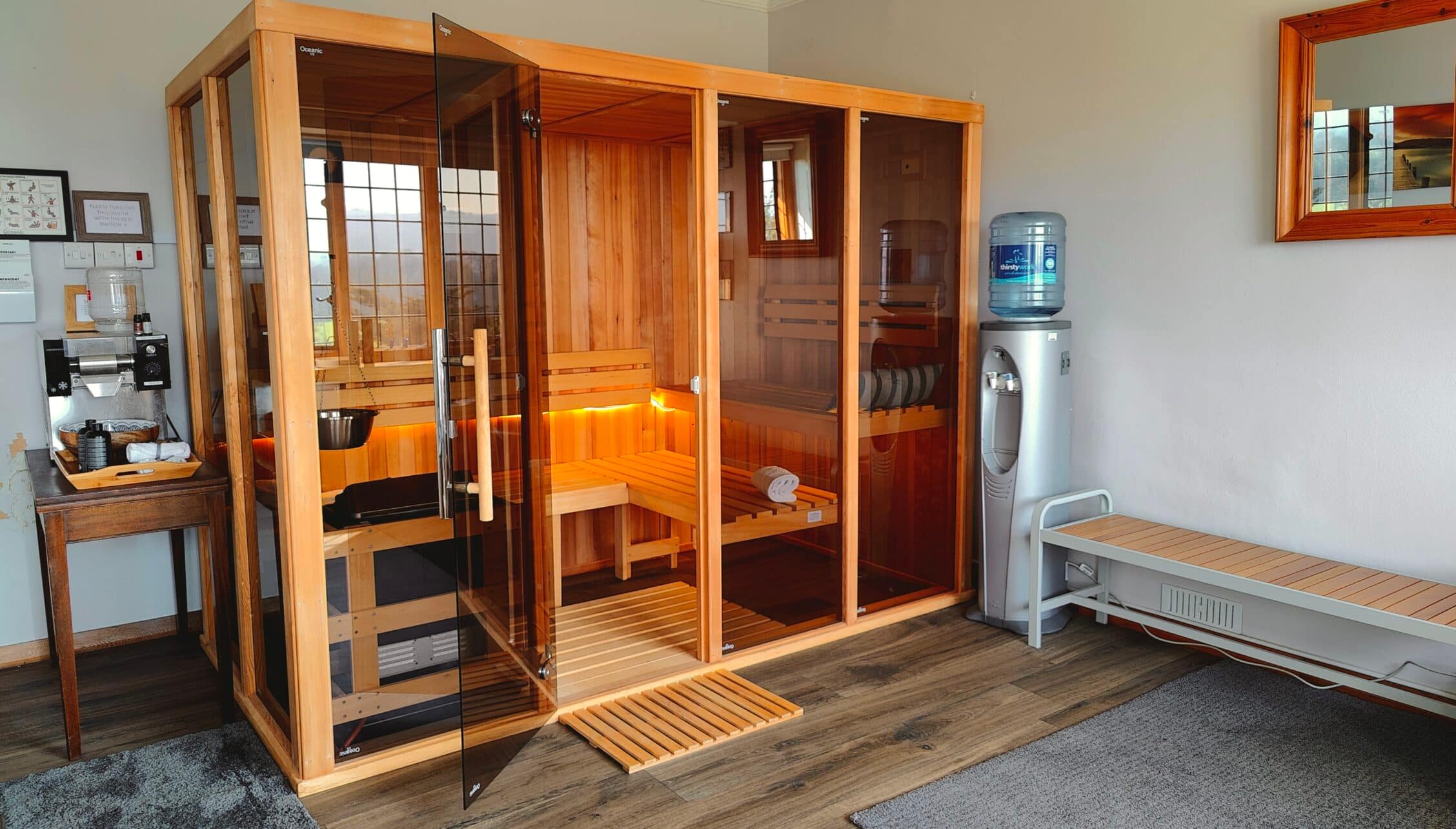 Bossington Hall, Somerset – Indoor sauna with glass doors and wooden benches in utility room.