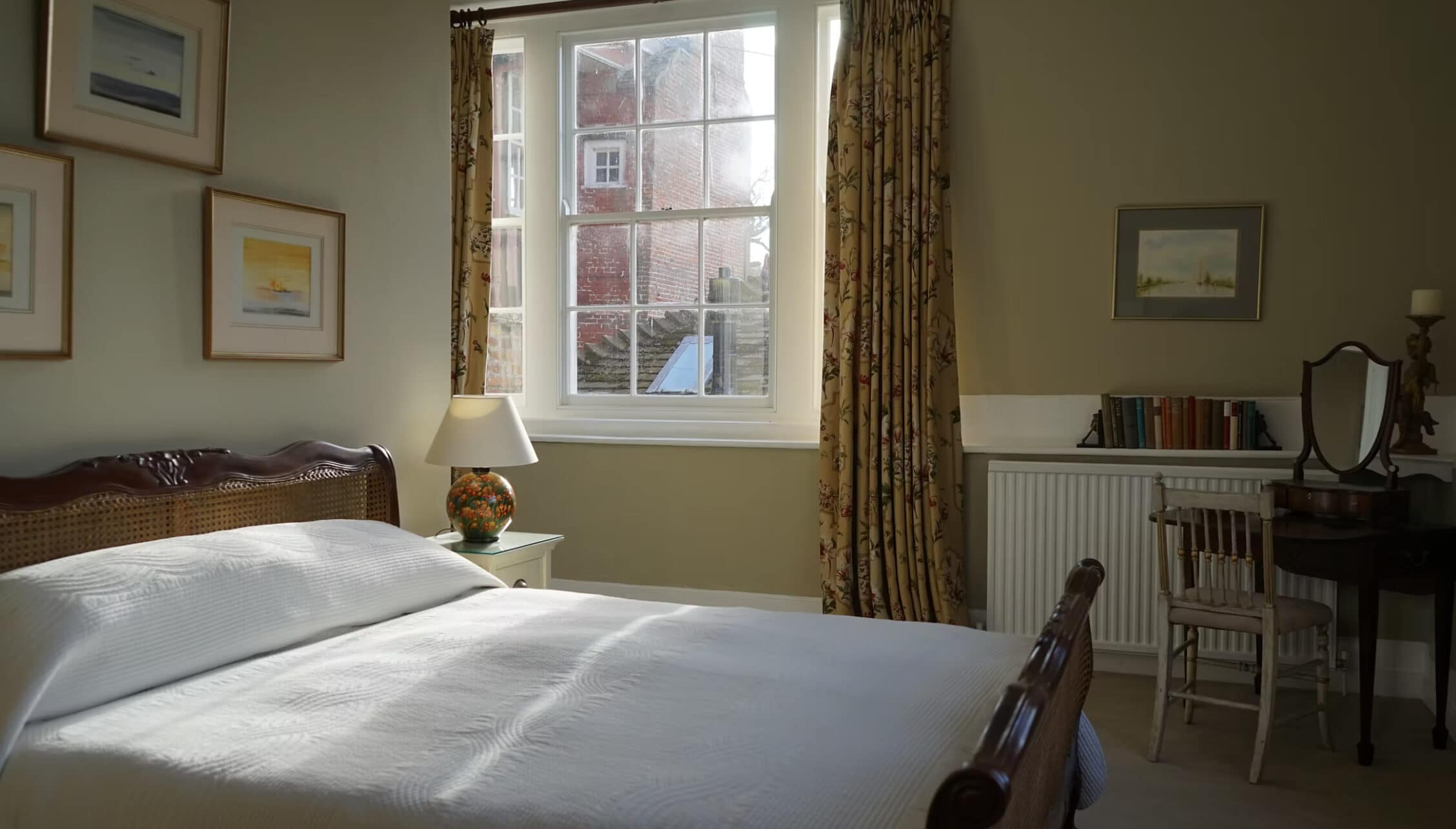 Boxted Hall, Suffolk – Bedroom with double bed, sash window overlooking countryside, and writing desk.