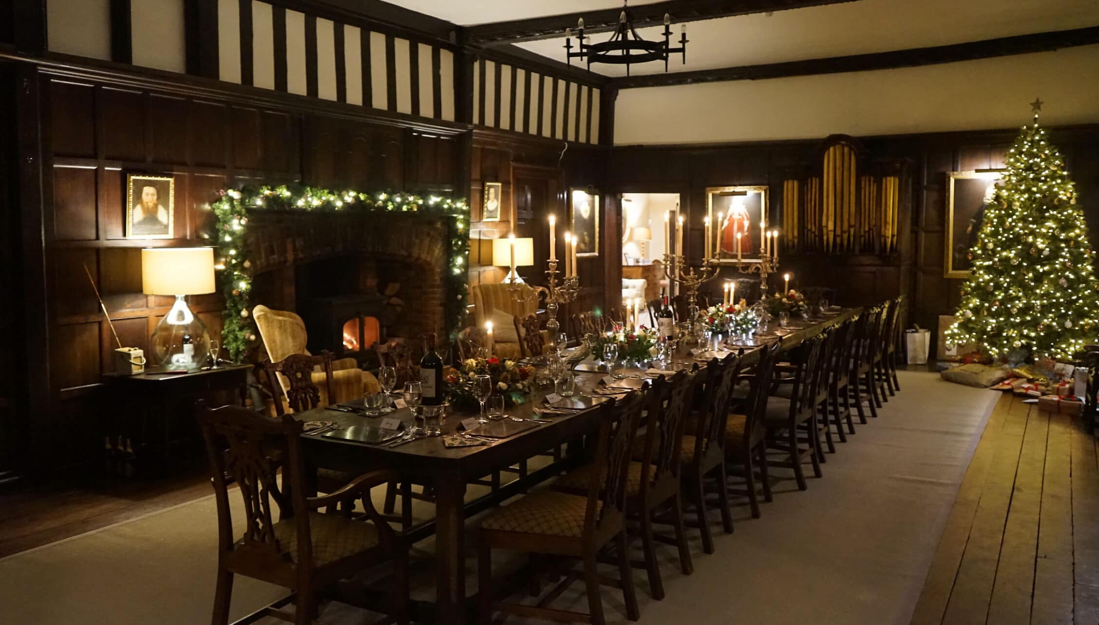 Boxted Hall, Suffolk – Tudor-style dining room with long dark wood table, fireplace and Christmas decorations.