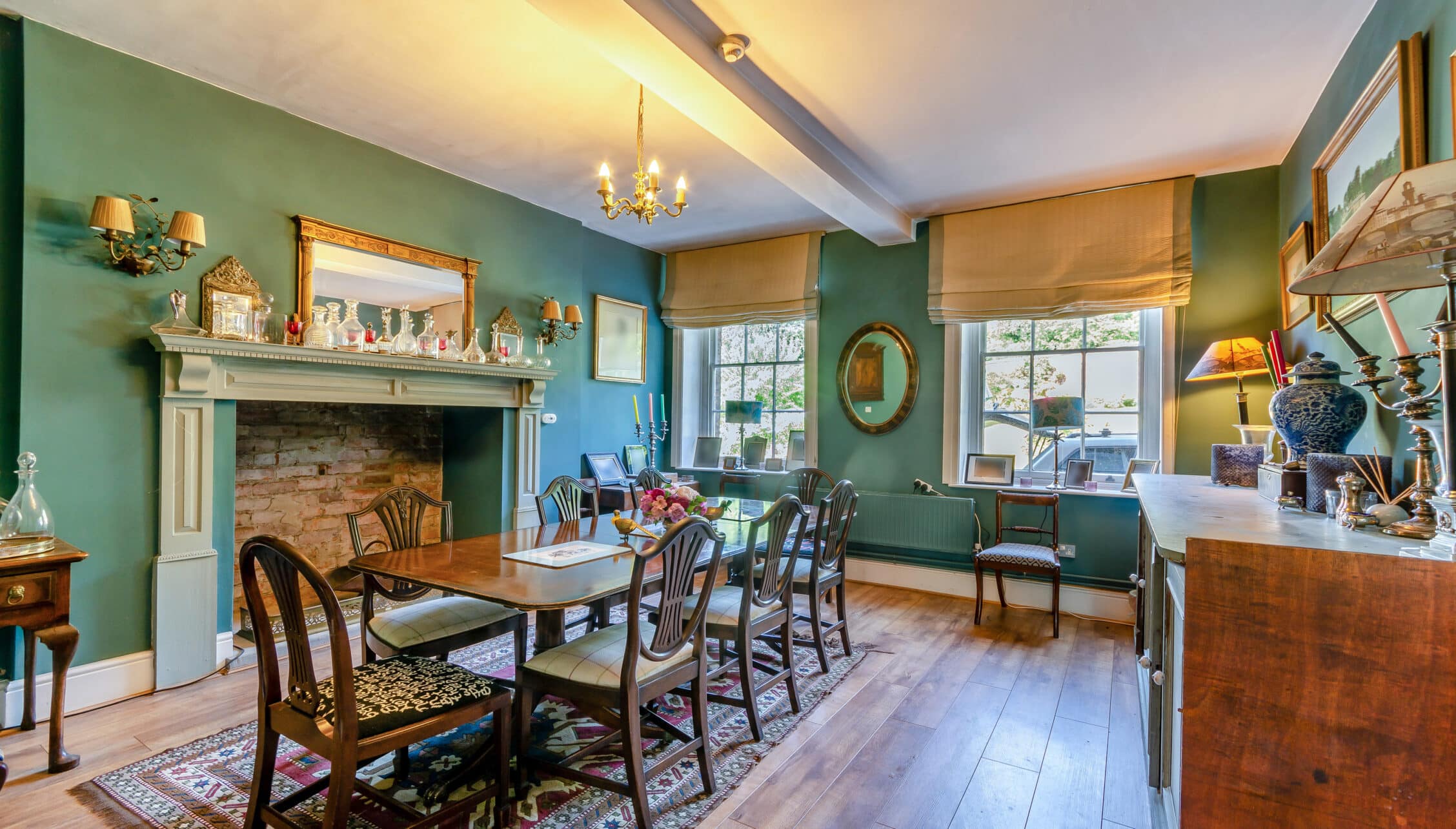 Breedon Hall, Leicestershire – Dining room with fireplace, green walls, and wooden table with six chairs.