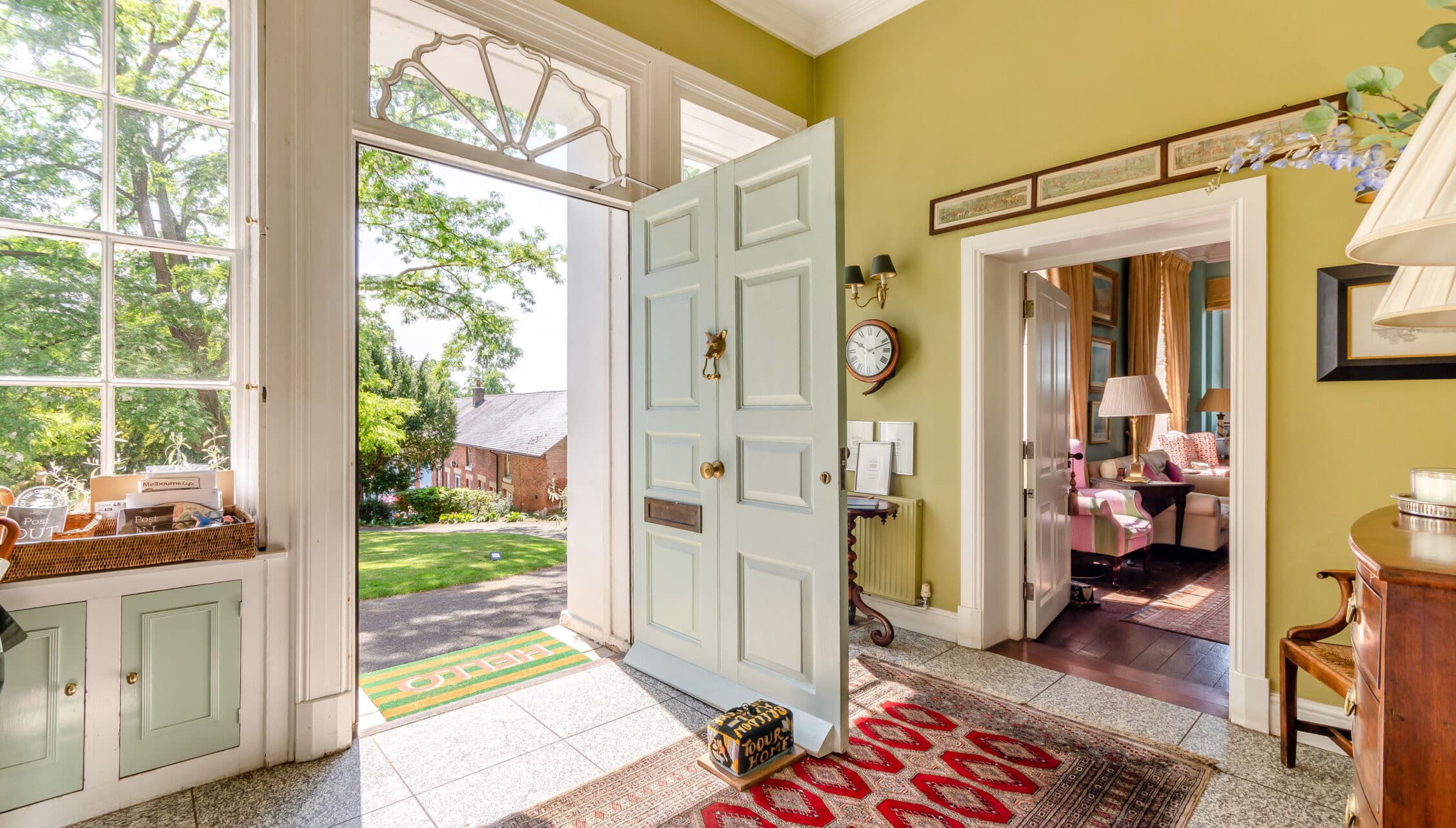 Breedon Hall, Leicestershire – Bright yellow entrance hall with pale green panelled door and large sash windows overlooking grounds.