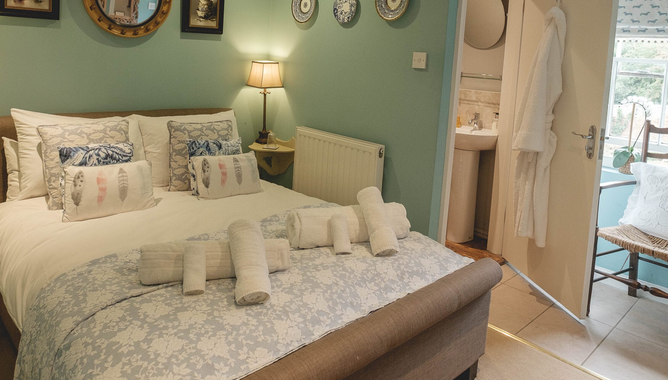 Breedon Hall, Leicestershire – Bedroom with sage green walls, decorative plates, and en-suite bathroom visible.