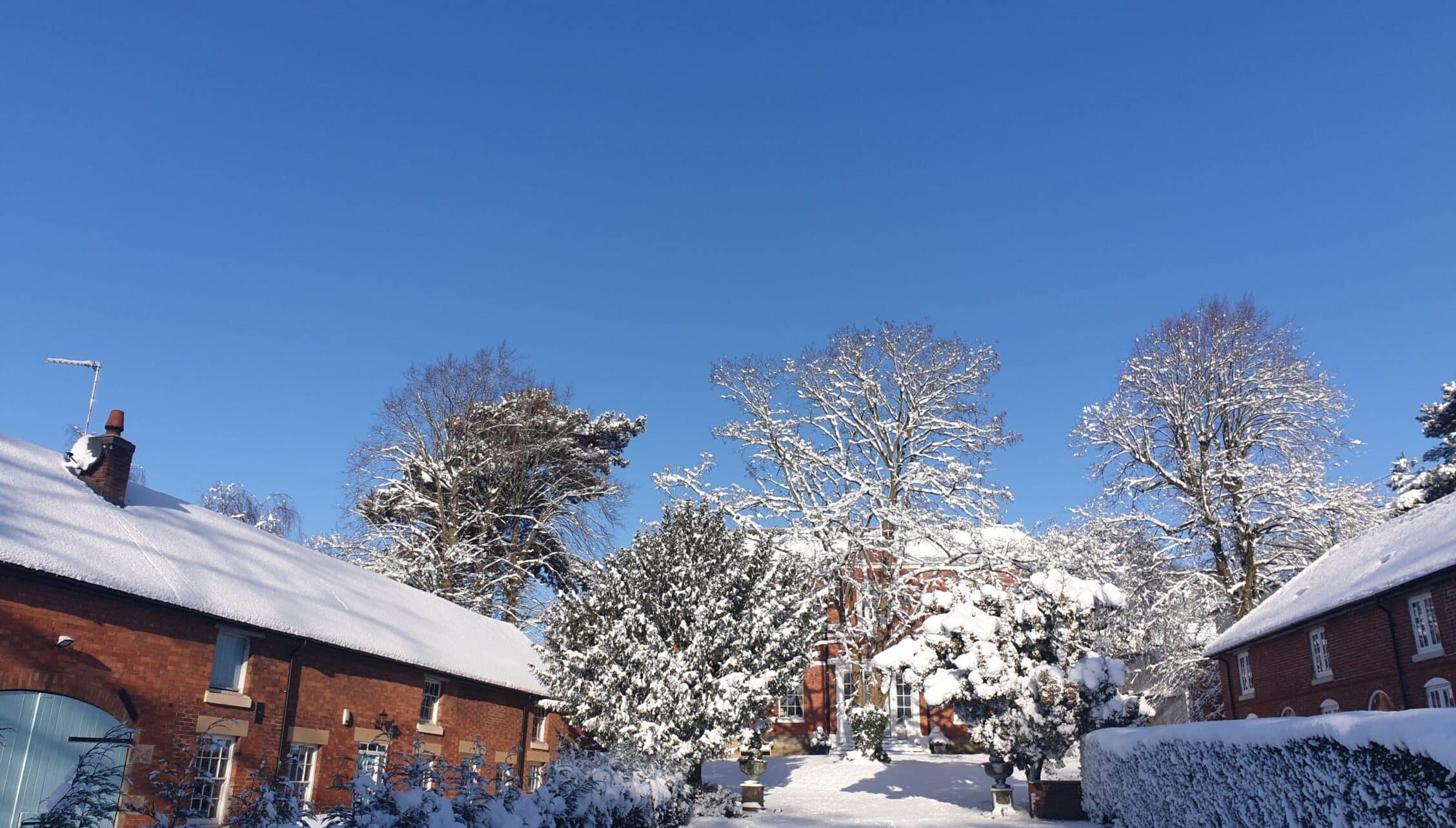 Breedon Hall, Leicestershire – Red brick converted farm buildings with snow-covered grounds and frost-laden trees.