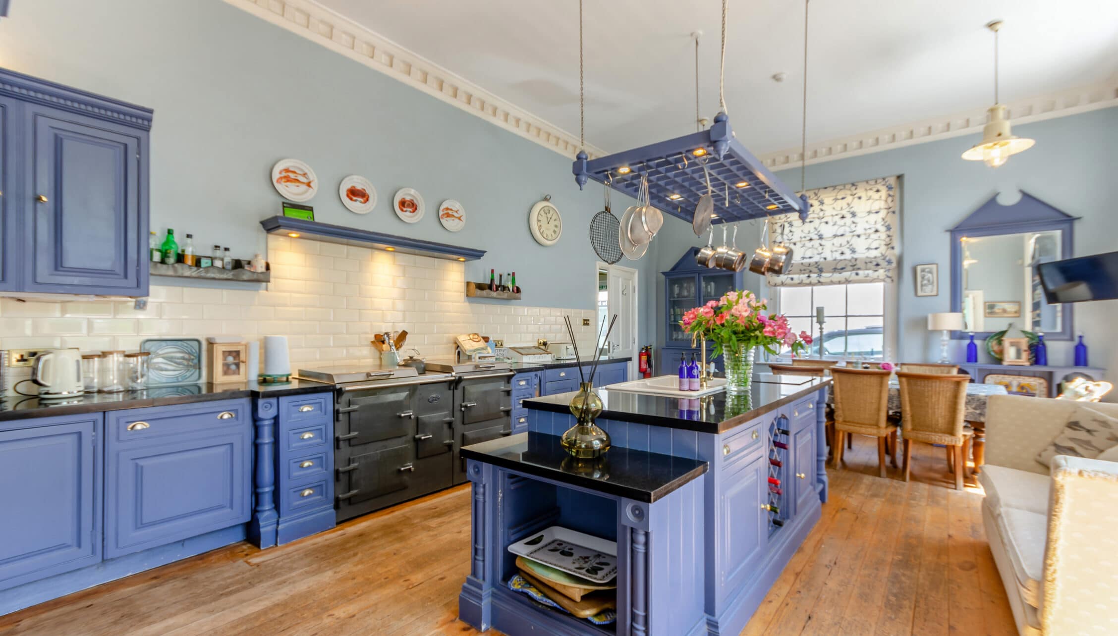 Breedon Hall, Leicestershire – Blue and navy kitchen with black Aga cooker, central island, and pendant lights.