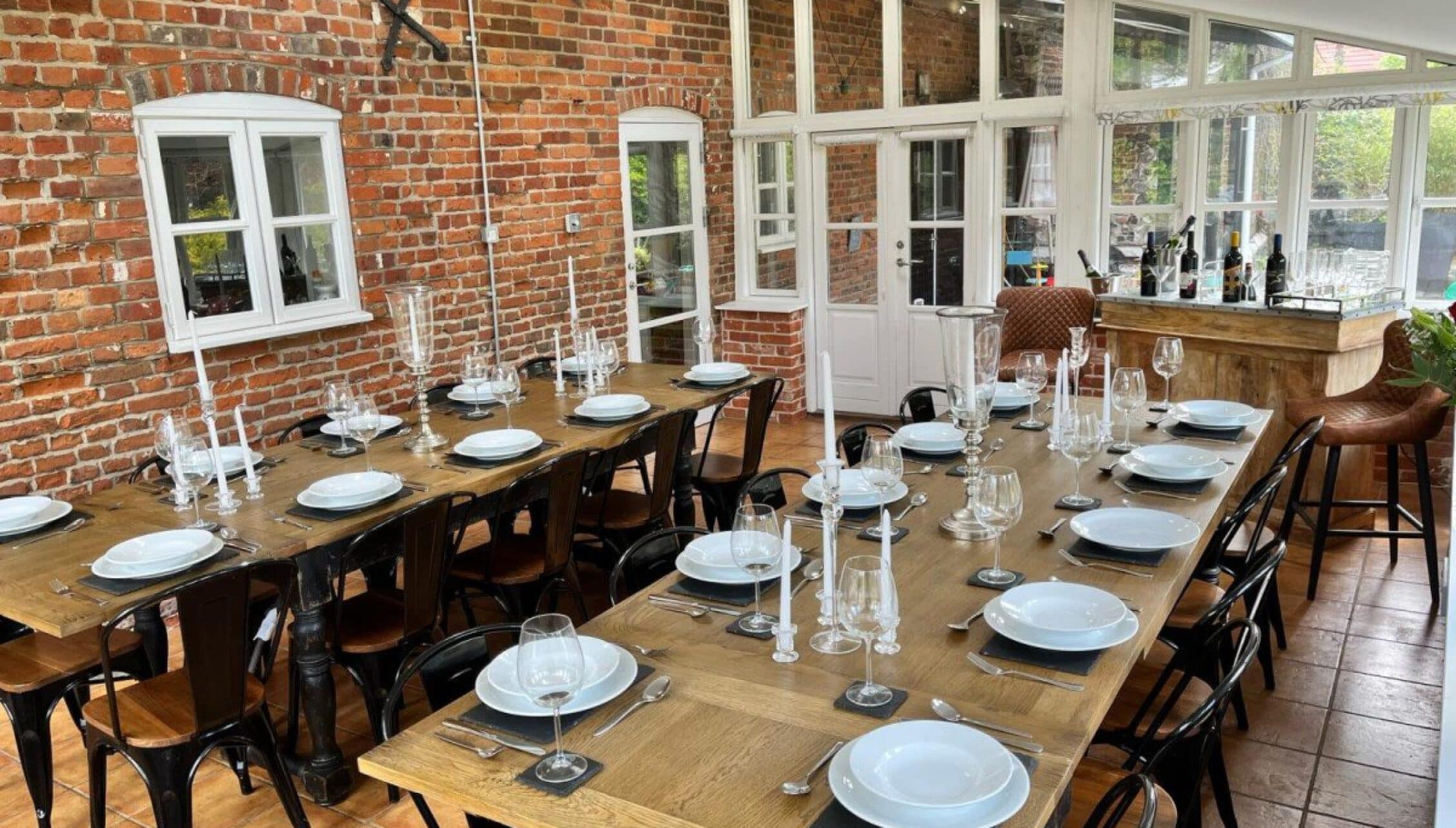 Catton Old Hall, Norfolk – Dining room with exposed brick walls, wooden tables, and large multi-pane windows.