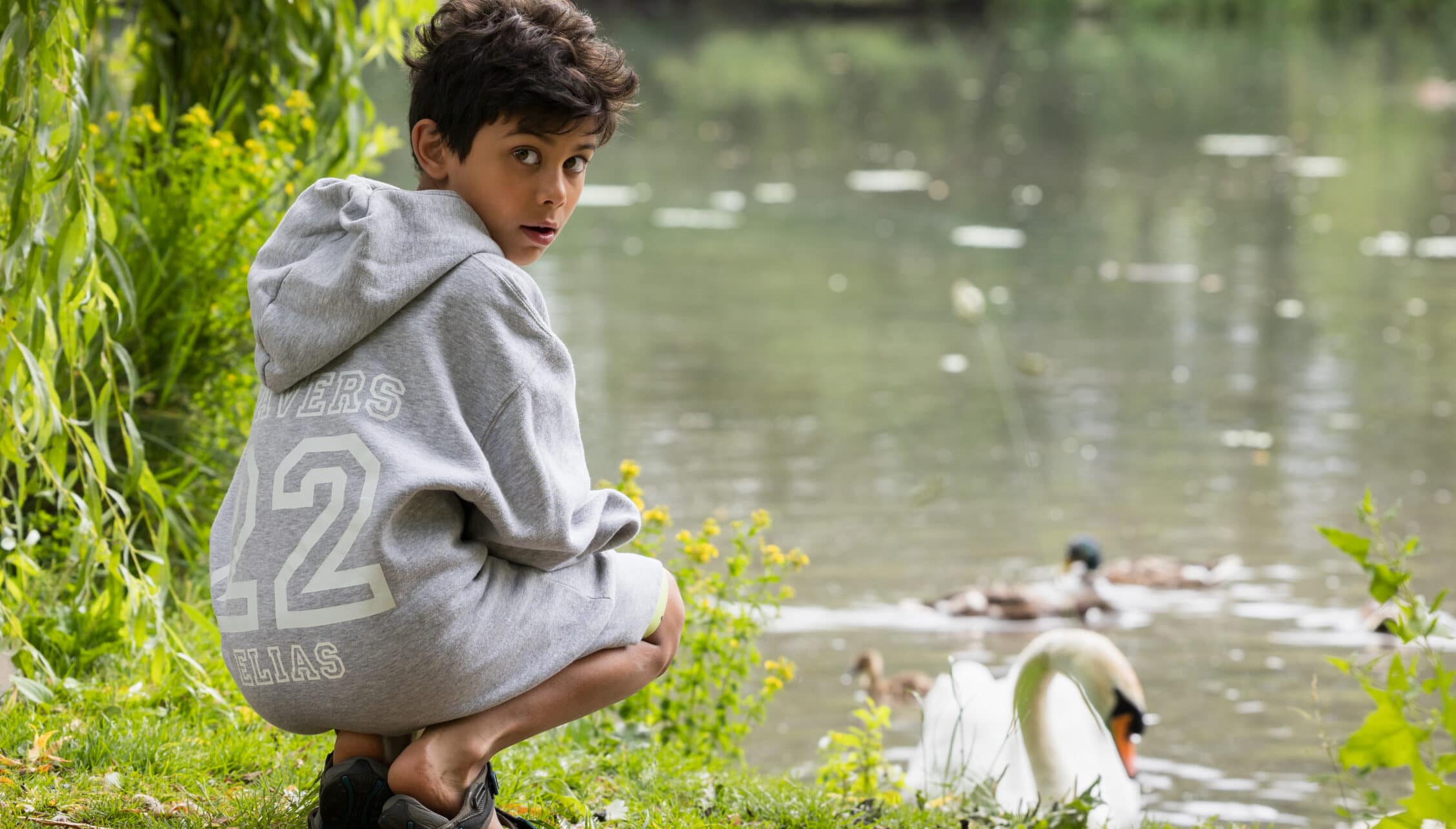 Courtyard Cottages, Gloucestershire – Child by riverside with weeping willow and waterfowl on water.