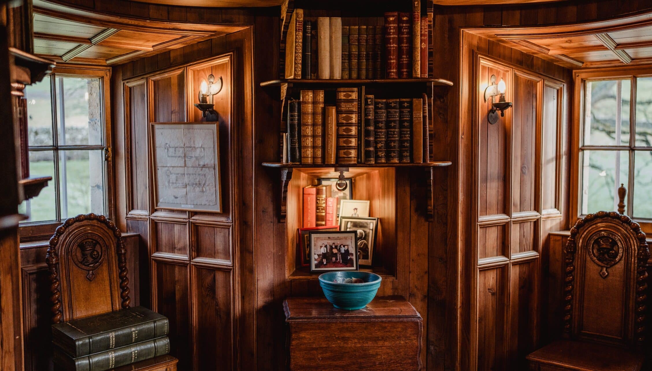 Ferniehirst Castle, East Lothian – Wood-panelled library interior with leather-bound books, ornate chairs and casement windows.