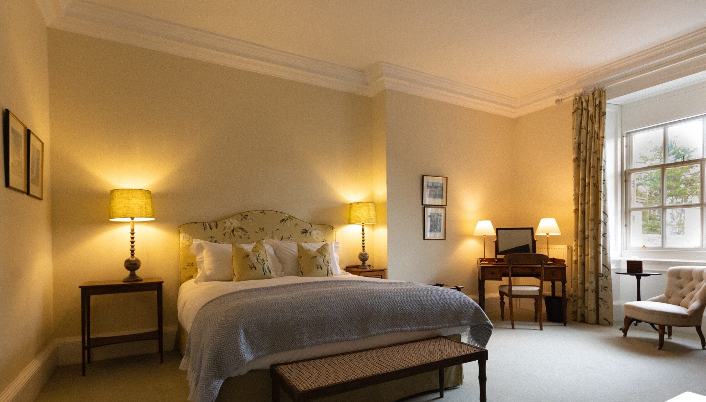 Gilmerton House, East Lothian – Bedroom with double bed, ornate headboard and twin bedside lamps.