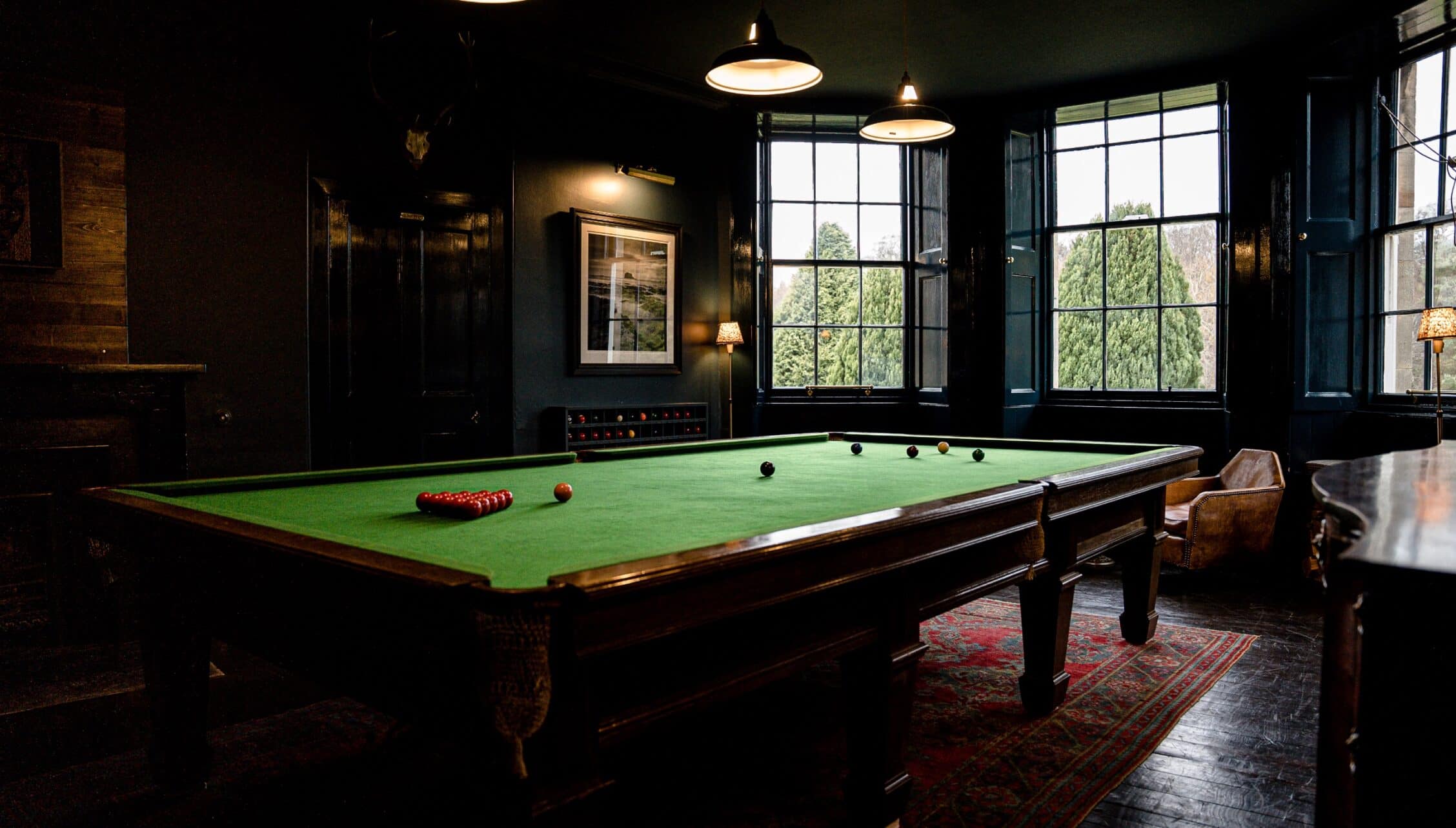Gilmerton House, East Lothian – Snooker room with dark walls, green baize table and large sash windows overlooking grounds.