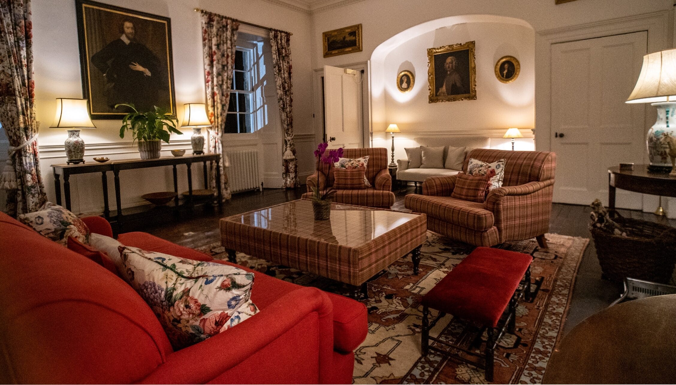 Gilmerton House, East Lothian – Formal drawing room with red sofas, tartan armchairs and portrait paintings.