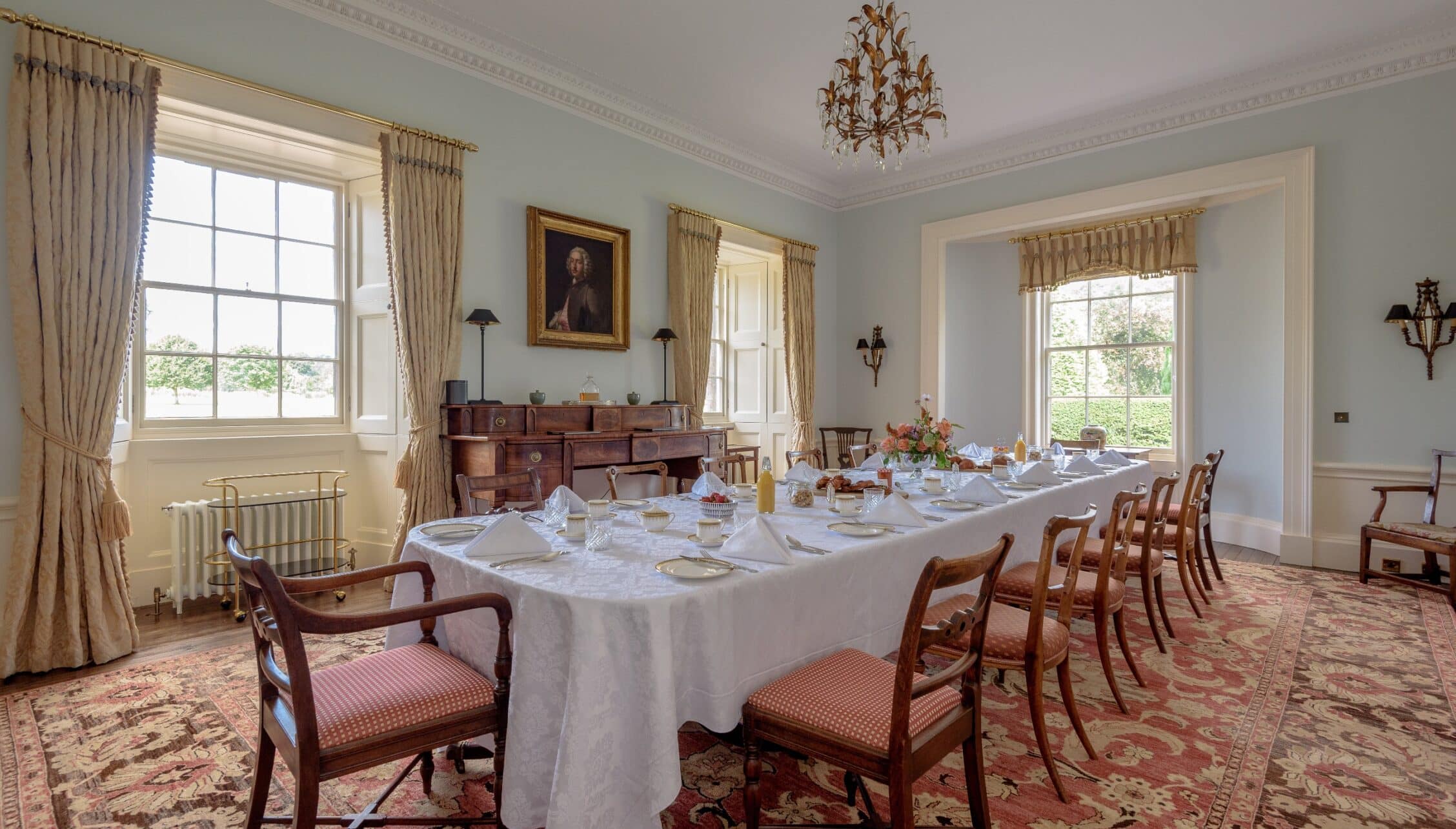 Gilmerton House, East Lothian – Formal dining room with long table, mahogany chairs, and brass chandelier.