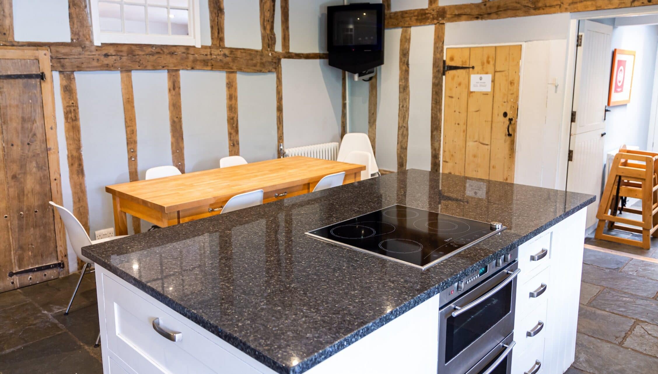 Hill House Norfolk, Norfolk – Modern kitchen with granite worktops, induction hob, and exposed oak beams.
