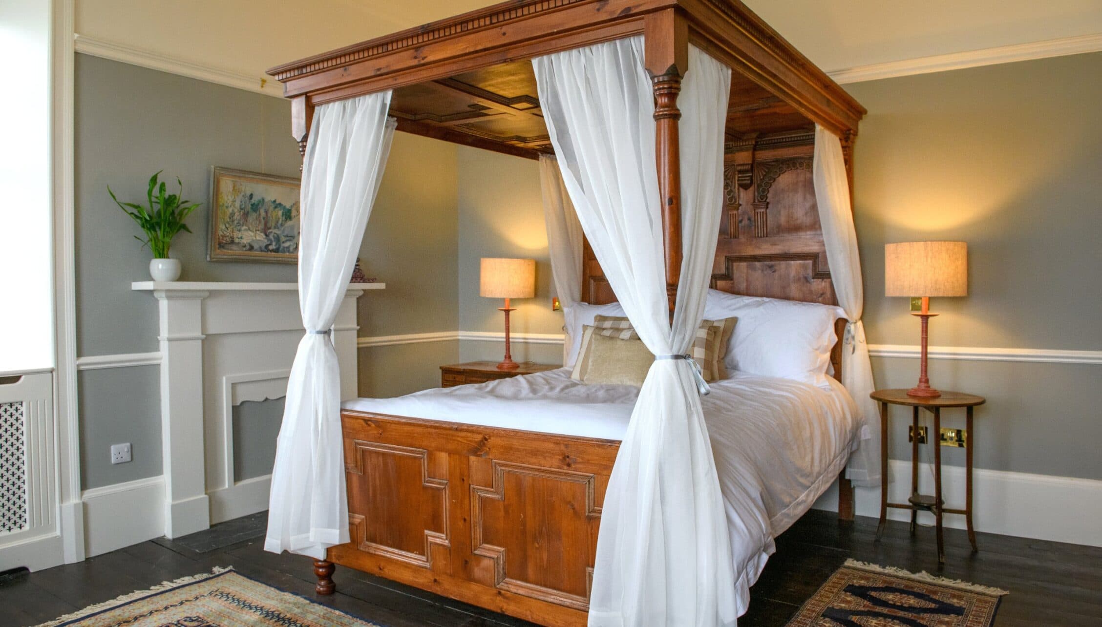 House of the Northern Gate, Highland – Four-poster bed with white curtains in traditionally decorated bedroom with panelled walls.