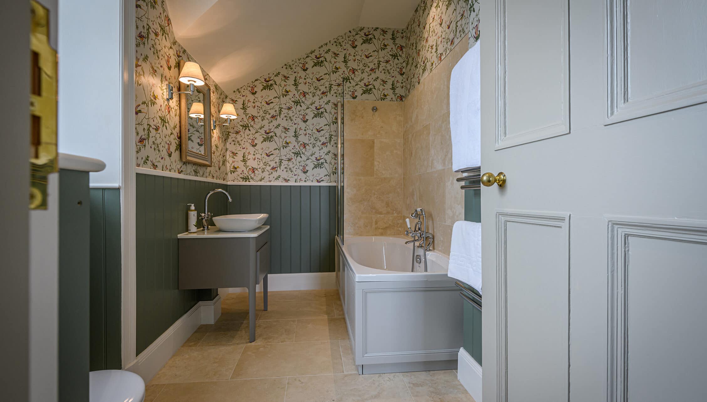 House of the Northern Gate, Highland – Ensuite bathroom with floral wallpaper, green panelling and freestanding bath.