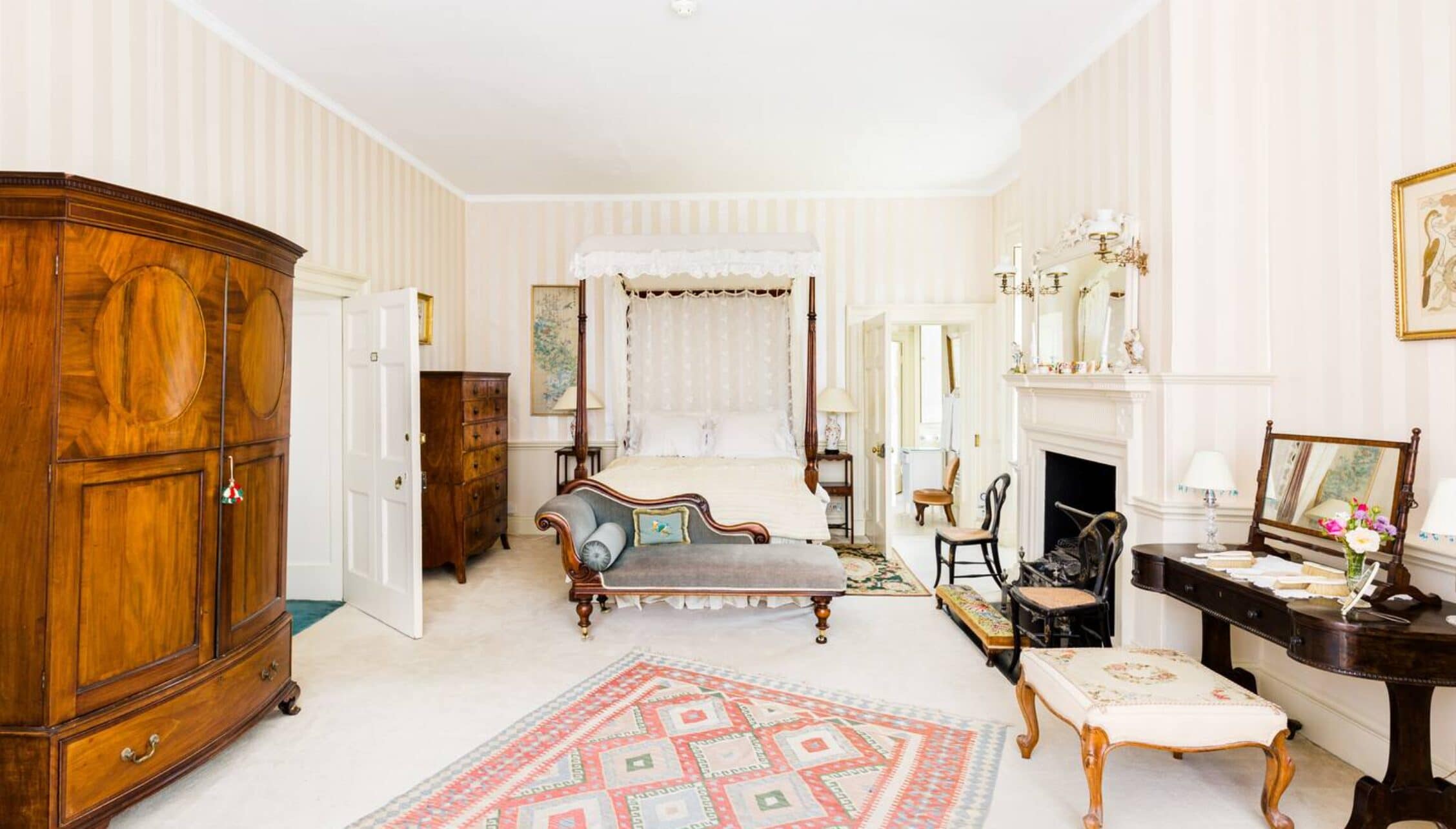 Upper Court, Gloucestershire – Spacious bedroom with four-poster bed, mahogany wardrobe and fireplace.