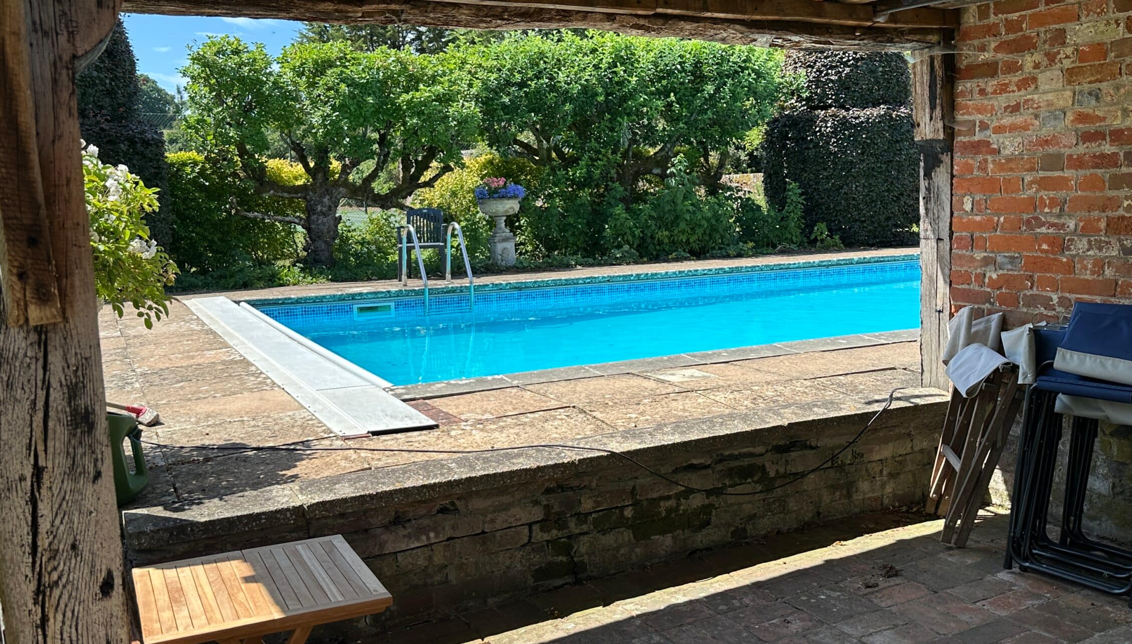 The Old House, Hampshire – Rectangular outdoor swimming pool with brick pavilion and manicured hedged gardens.