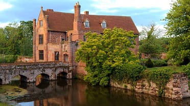 Crow’s Hall, Suffolk – Red brick Georgian mansion with moat and arched stone bridge.