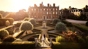 Berwick House, Shropshire – Red-brick country house with formal parterre garden and topiary at sunset.