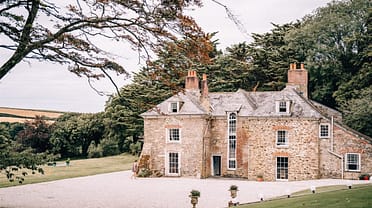 Tredudwell Manor, Cornwall – Georgian brick manor with slate roof and tall chimneys, approached by gravel driveway and mature grounds.
