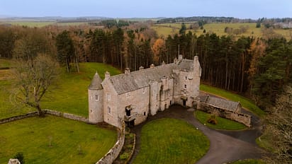 Ferniehirst Castle, East Lothian – Stone castle with conical towers surrounded by woodland and rolling farmland.