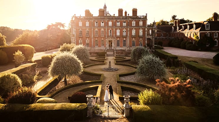 Berwick House, Shropshire – Red-brick country house with formal parterre garden and topiary at sunset.