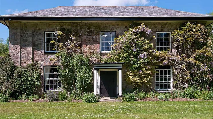 Old Rectory and Coach House – Stone country house with ivy-covered façade, sash windows and wisteria flowering climbers.