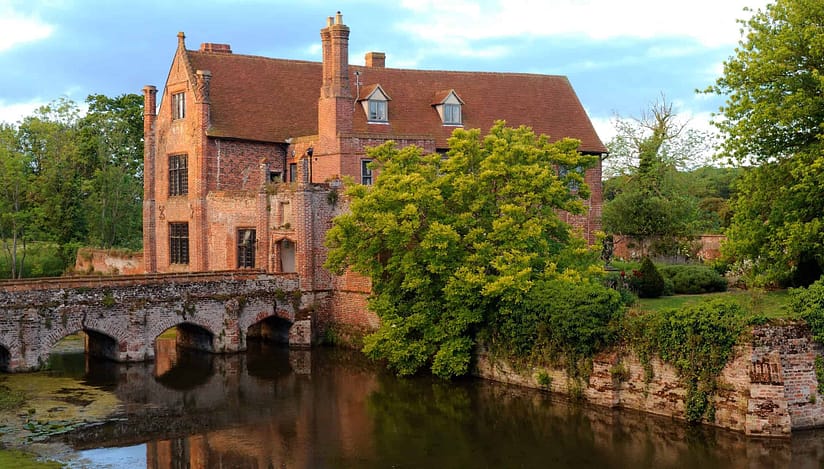 Crow’s Hall, Suffolk – Red brick Georgian mansion with moat and arched stone bridge.
