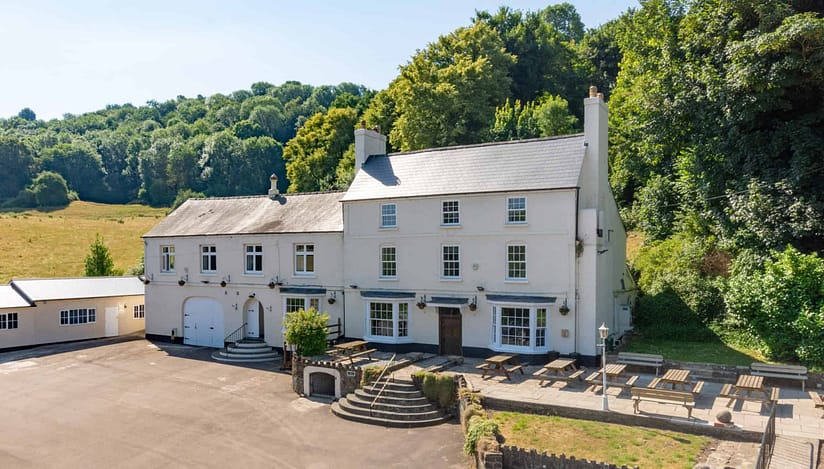 River Wye Lodge, Gloucestershire – Whitewashed Georgian manor with slate roof, surrounded by mature woodland and open parkland.