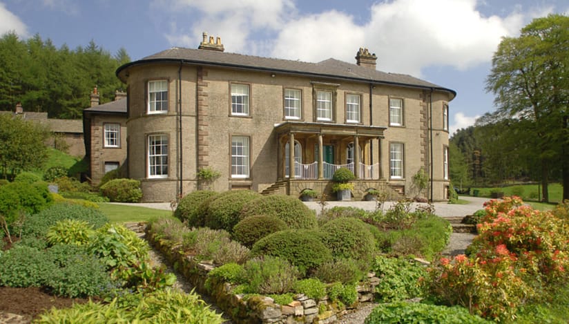 Crag Hall, Cheshire – Stone country house with columned portico and formal landscaped gardens featuring topiary and shrubs.
