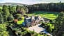 Elm Lodge, Cumbria – Victorian sandstone country house with slate roof surrounded by mature woodland and open parkland.
