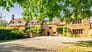 Tysoe Manor, Warwickshire – Stone manor house with mullioned windows and gravel driveway, shaded by mature trees.