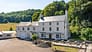 River Wye Lodge, Gloucestershire – Whitewashed Georgian manor with slate roof, surrounded by mature woodland and open parkland.